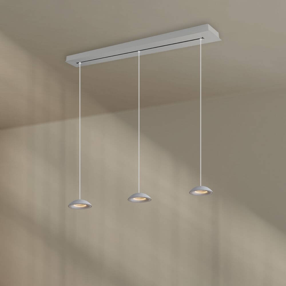 s.luce Santa Air LED Esszimmer-Pendelleuchte 3-flammig 120cm schwebt elegant über einem Esstisch.