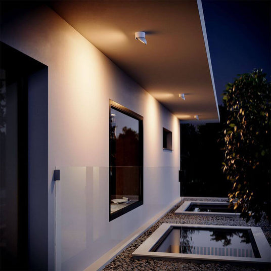 s.luce Santa Out LED Aussen-Deckenleuchte IP65 drehbar an moderner Fassade mit stimmungsvollem Licht