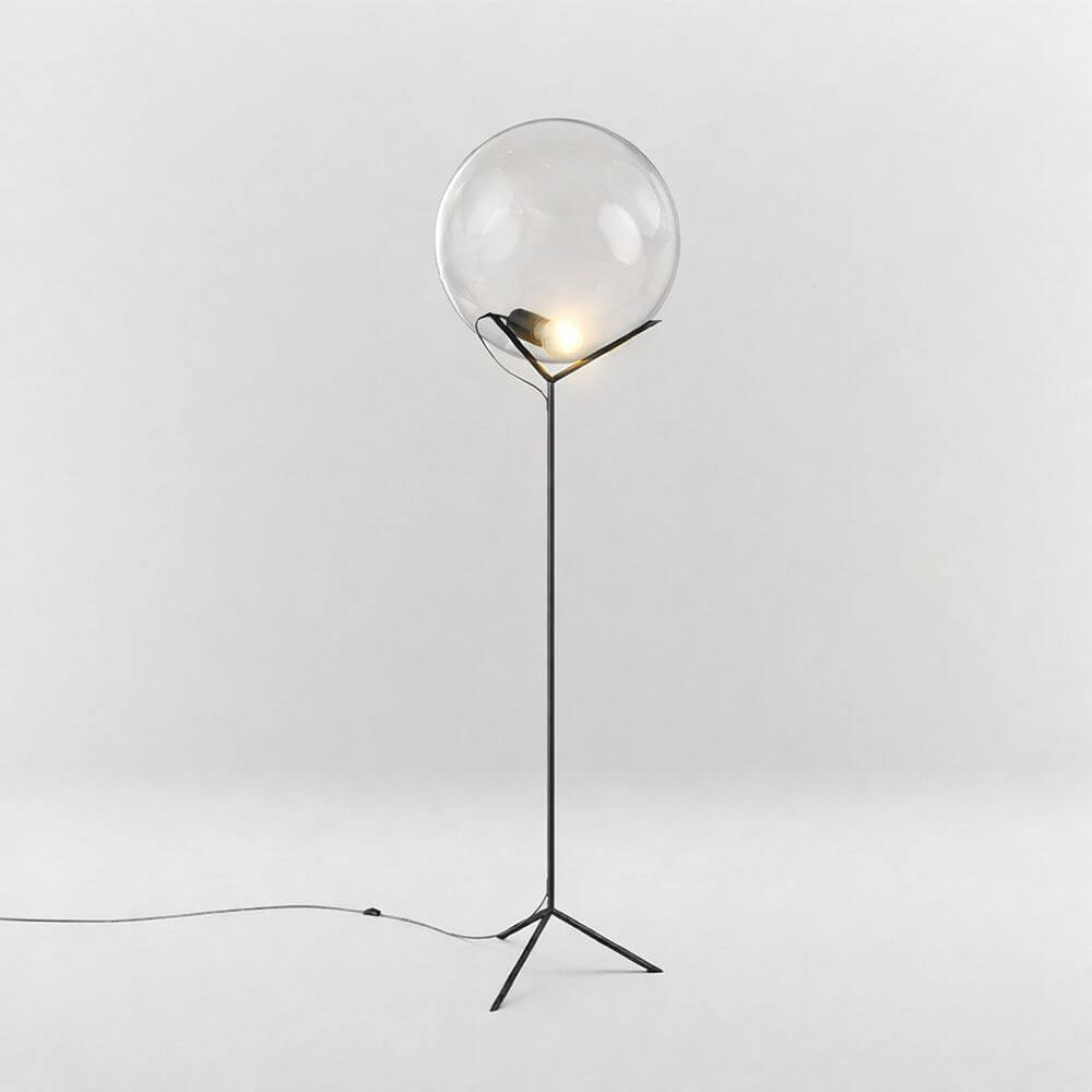 s.luce Stehleuchte Orb Poseidon mit Glaskugel 175cm auf einem filigranen Gestell im modernen Raum.