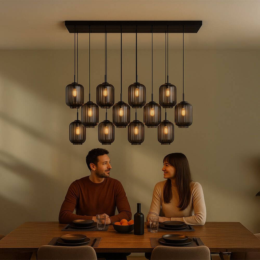 s.luce Velo Esstischlampe 12-flammig 200cm 3-reihig Ø 20cm über einem stilvollen Esstisch mit Personen.