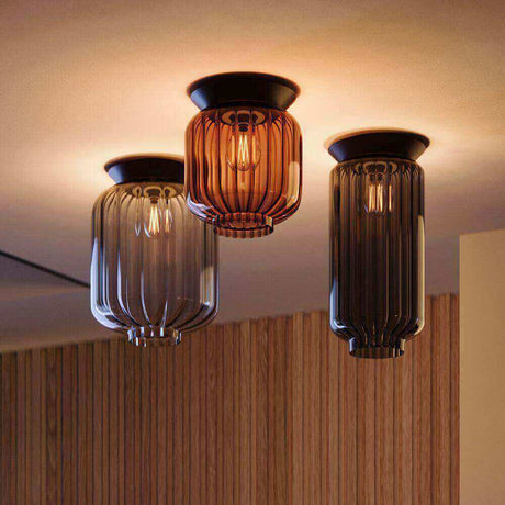 Drei stilvolle gläserne Deckenlampen in Grau, Braun und Schwarz mit eleganter Beleuchtung.