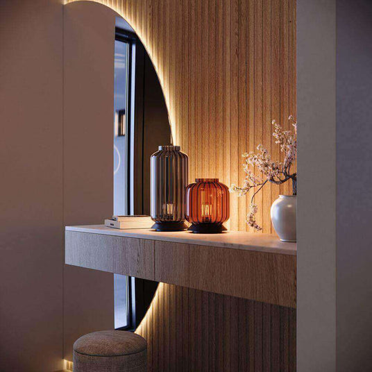 Moderne Wandnische mit dekorativen Vasen und Beleuchtung, harmonisch gestaltet in einem stilvollen Raum.