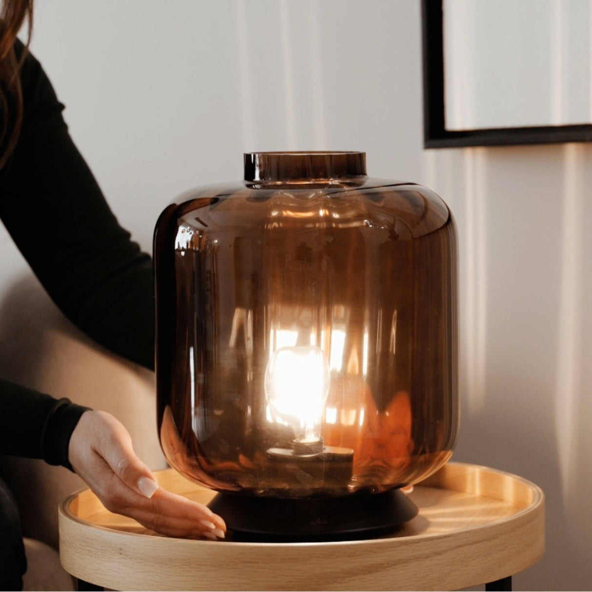 s.luce Velo Glas-Tischleuchte mit Schalter auf einem Tisch, elegant und stilvoll in Rauchglas.