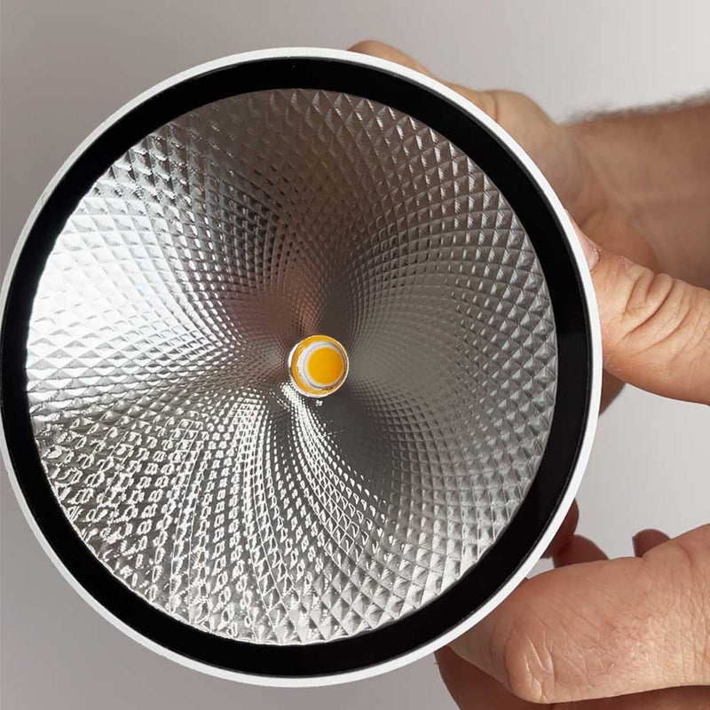 Helle s.luce Lampe mit reflektierendem Innenraum und einem gelben Lichtpunkt in der Mitte.