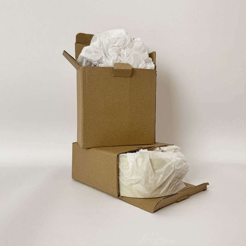 Braune Kartons mit Papierfüllung, ideal für Verpackung und Versand in umweltfreundlicher Verpackung.