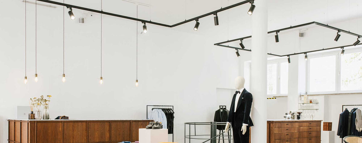 Eleganter Modeboutique-Innenraum mit Schaufensterpuppen, Kleiderständern und moderner Beleuchtung