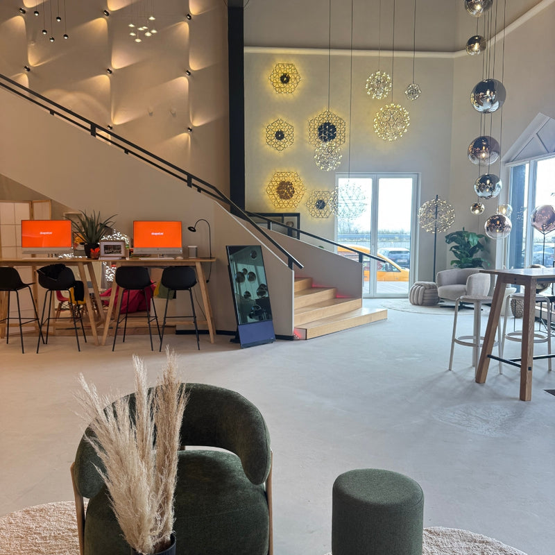 Heller moderner Innenraum mit stilvollen Möbeln, dekorativen Leuchten und Empfangstresen.