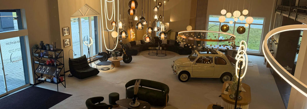 Elegante Inneneinrichtung mit modernen Leuchten und einem klassischen Auto in einem großzügigen Showroom.