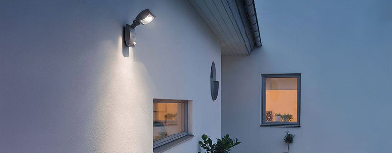 Hausbeleuchtung an einer weißen Wand, die gemütliche Atmosphäre am Abend betont.