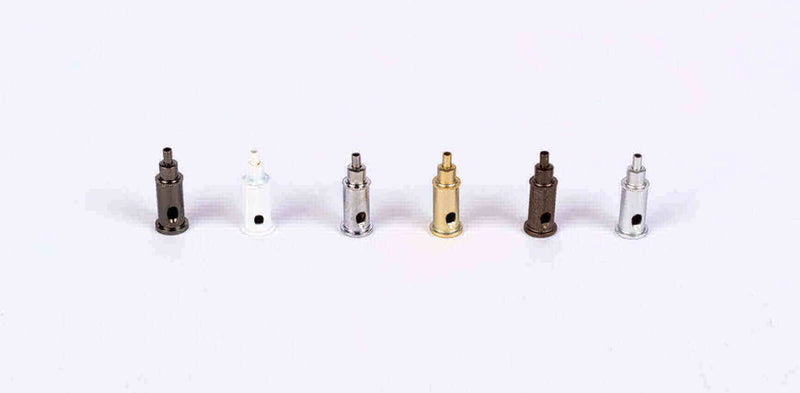 Sechs verschiedene Ventile in Schwarz, Weiß, Gold und Silber auf hellem Hintergrund.