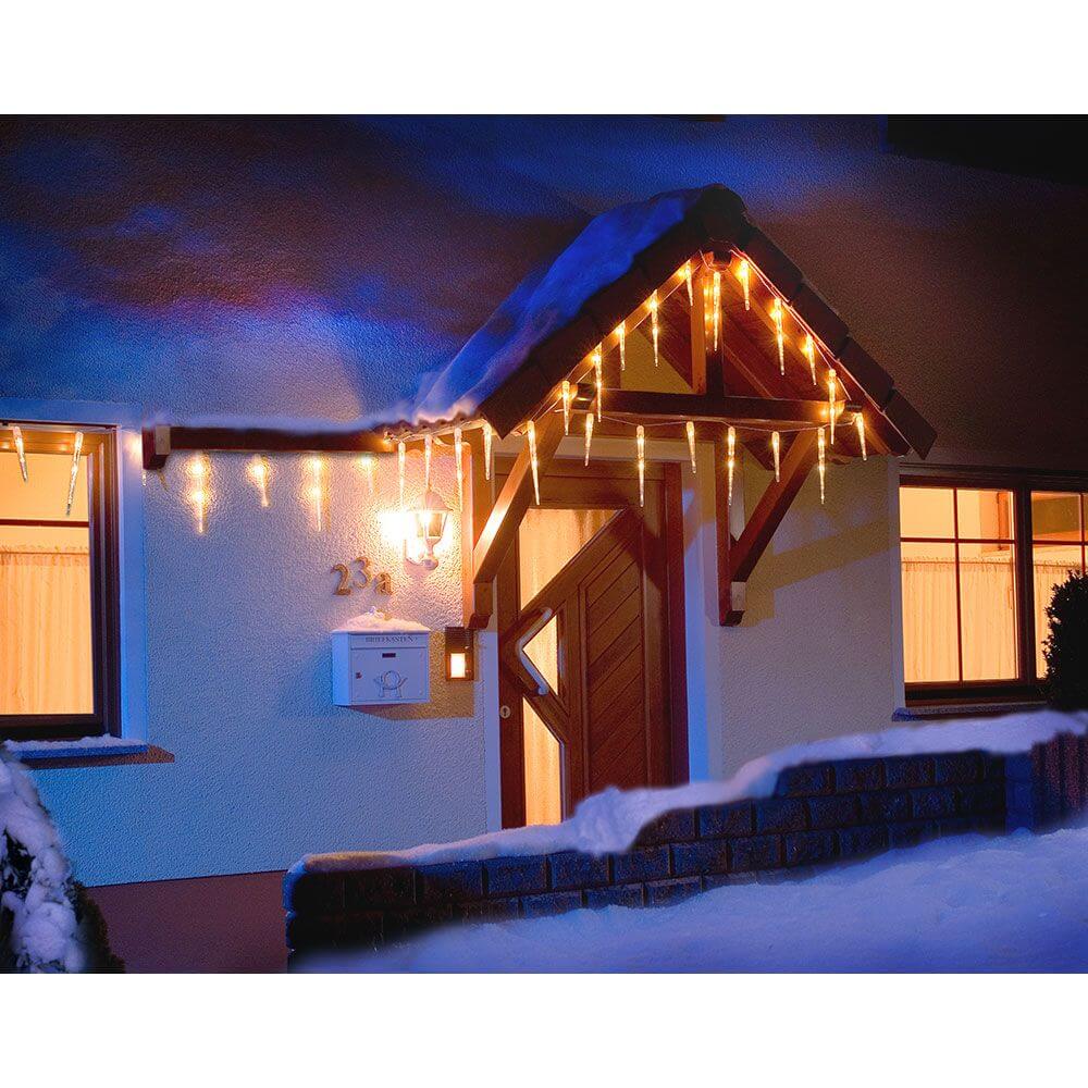 LED Eiszapfen Lichtervorhang 32 Zapfen 48 Kaltweiße Dioden IP44 am winterlichen Haus mit Schnee.