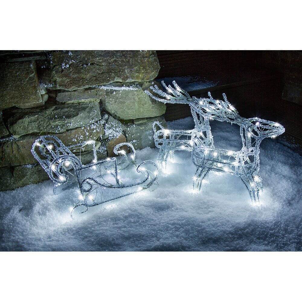 LED Acryl-Set Schlitten mit 2 Rentieren 96 Kaltweiße Dioden 24V in einer Winterlandschaft