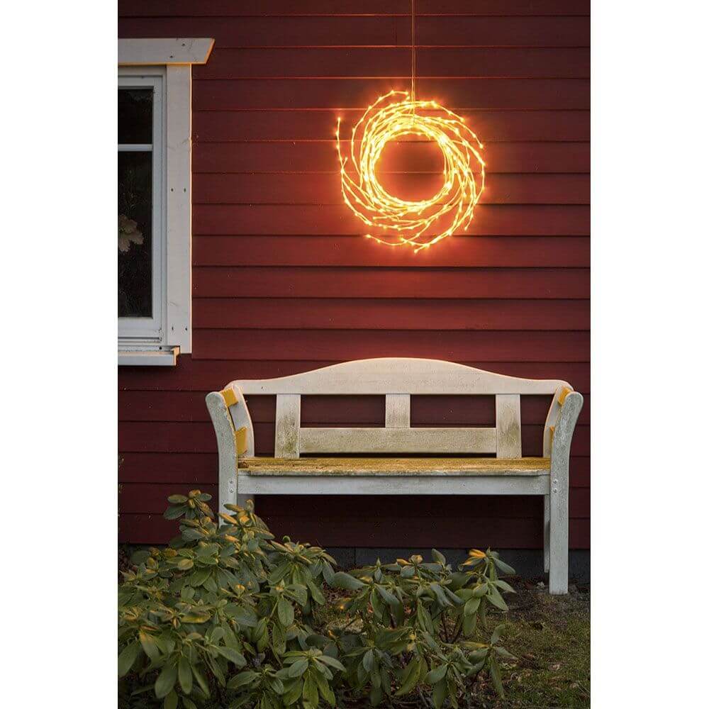 LED Dekoration variabel als Lichterkranz Lichtergirlande weiß 240 Warmweiße Dioden IP44 an roter Wand über einer Bank