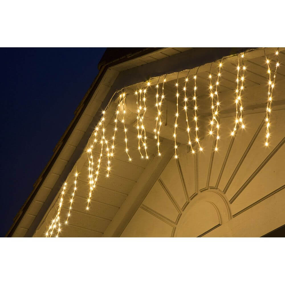 LED Dekoration variabel als Lichterkranz Lichtergirlande weiß 240 Warmweiße Dioden IP44 an einem Hausdach bei Nacht.