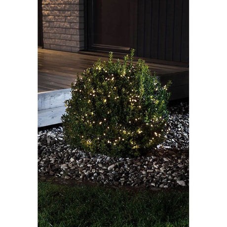 LED Büschelllichterkette Cluster Lichtsensor 240 Warmweiße Dioden batteriebetrieb IP44 beleuchtet einen Gartenbusch.