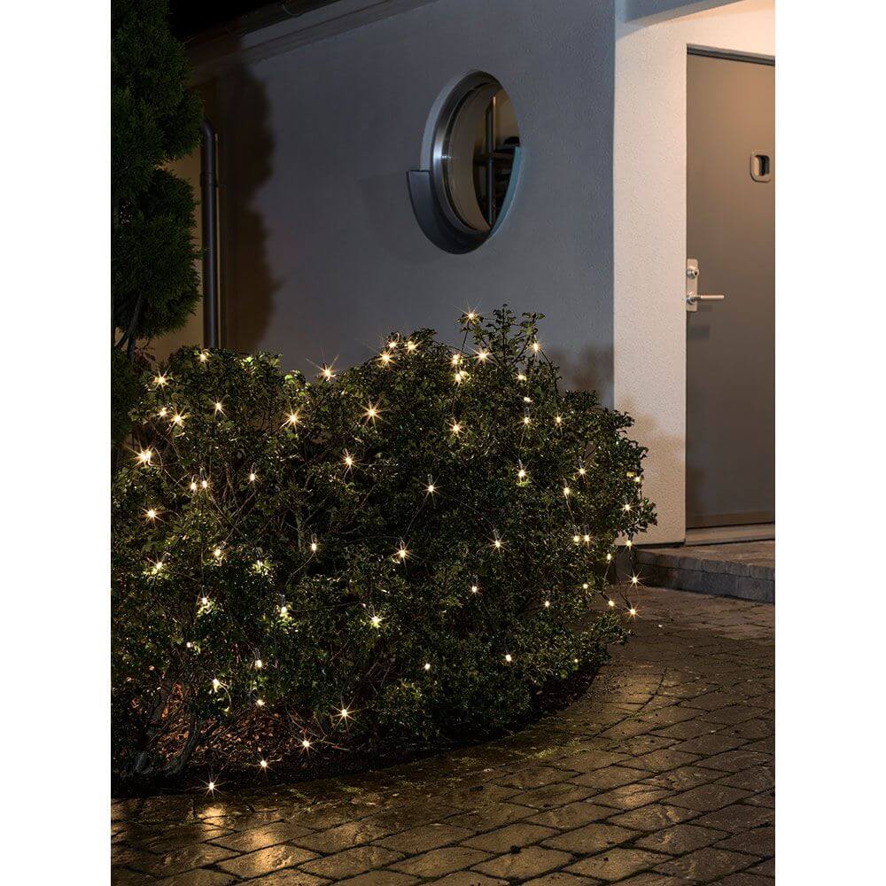 Maxi LED System Erweiterung Lichternetz 104 Dioden Warmweiß IP44 in dekorativen Sträuchern im Garten bei Nacht.