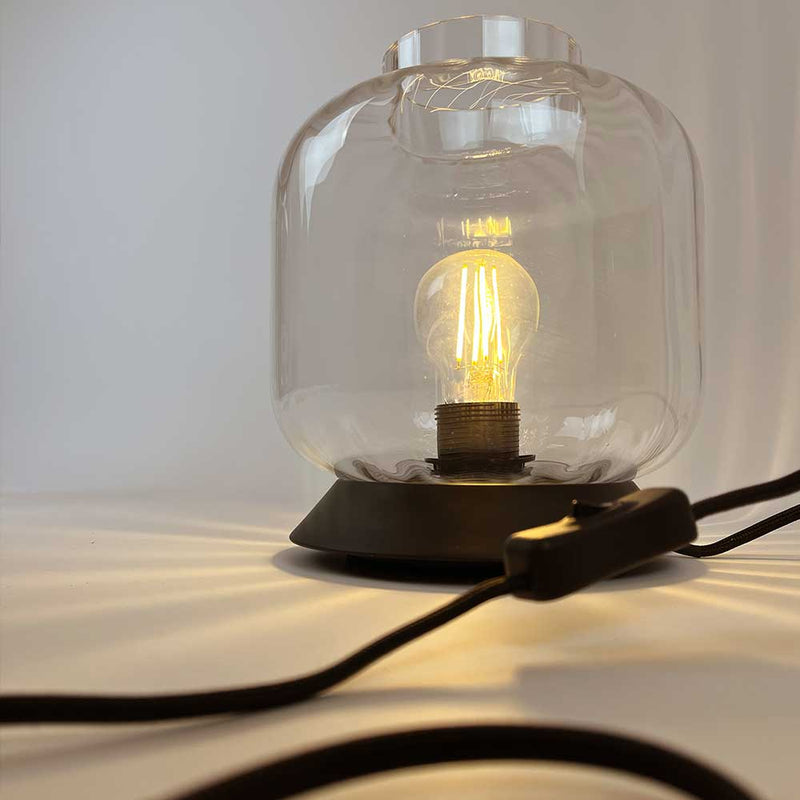 Moderne Tischlampe mit Glasabdeckung und Edison-Glühbirne, ideal für stimmungsvolle Beleuchtung.