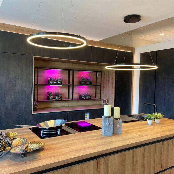 Moderne Küche mit runden Hängeleuchten, Holzarbeitsfläche und stilvoller Ausstattung in einem Wohnambiente.