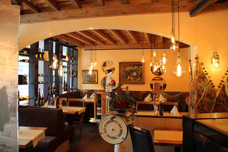 Gemütliches Restaurant mit stilvoller Beleuchtung und Holzdecke, ideal für eine angenehme dining Atmosphäre.