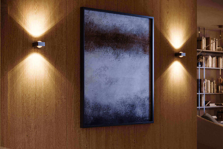 Moderne Wandleuchten in Szene setzen mit stilvoller Beleuchtung und Kunstwerk an Holzwand.