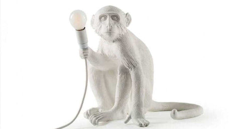 Affenlampe in Form eines sitzenden Affen, der eine Glühbirne hält, moderne und kinderfreundliche Beleuchtung.