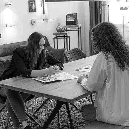 Ein Praktikum bei skapetze®: zwei Frauen besprechen Ideen an einem Tisch.