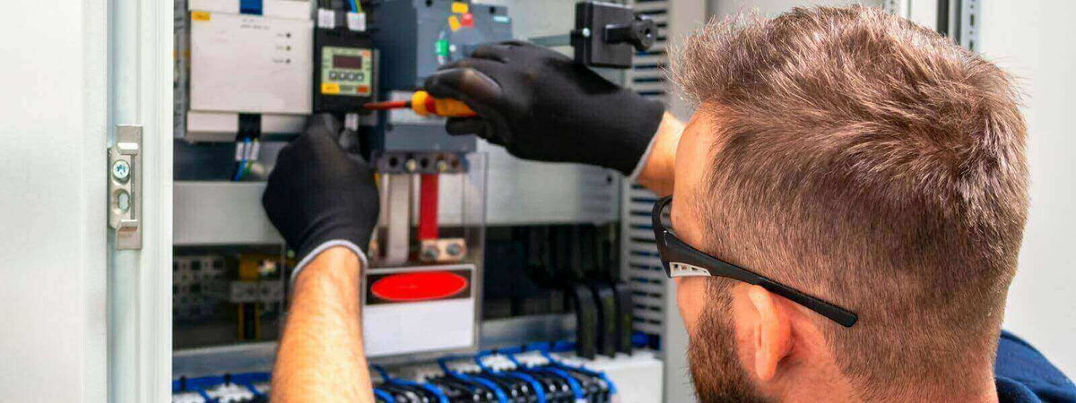 Techniker bei der Problemlösung für summende Lampen im Sicherungskasten, Servicetechniker bei der Arbeit.