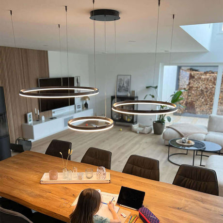 Moderne LED-Pendelleuchte über einem Esstisch in einem stilvollen Wohnzimmer.