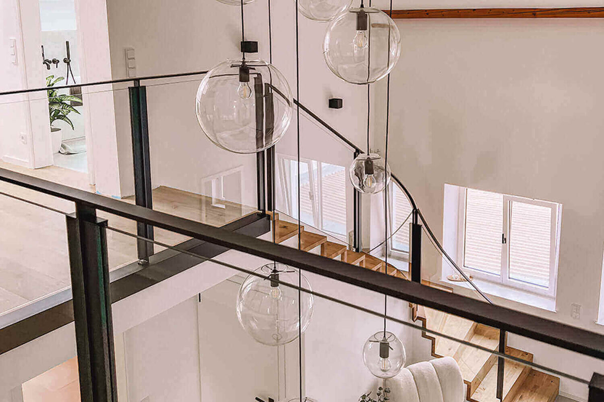 Herkömmliche Beleuchtung vs. Galeriebeleuchtung im Treppenhaus: Ein Beleuchtungsvergleich mit modernem Treppenhausdesign.