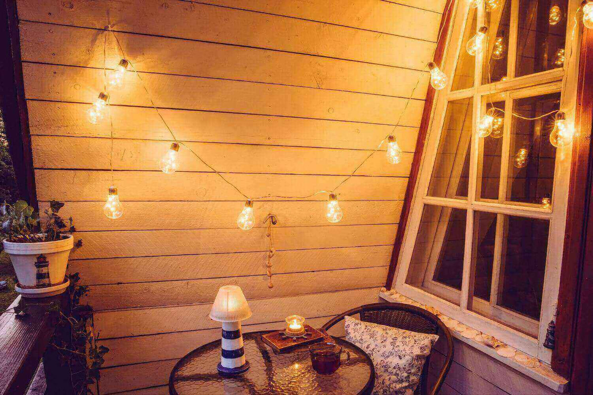 Stimmungsvolle Balkonbeleuchtung mit Lichtern und gemütlicher Atmosphäre auf einer Terrasse.