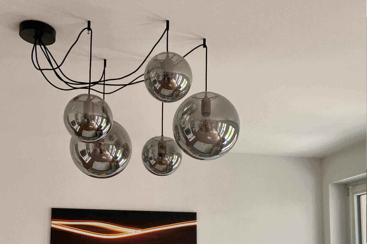 Moderne Deckenlampe mit fünf schimmernden Glaskugeln in einem stilvollen Raum.