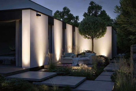 Moderne Gartenbeleuchtung mit LED-Lichtern an einem stilvollen Haus bei Nacht.