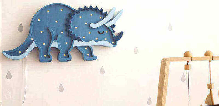 Dino-Lampen - Dinosaurier fürs Kinderzimmer, blaue Triceratops-Lampe an Wand mit Tropfenmuster.