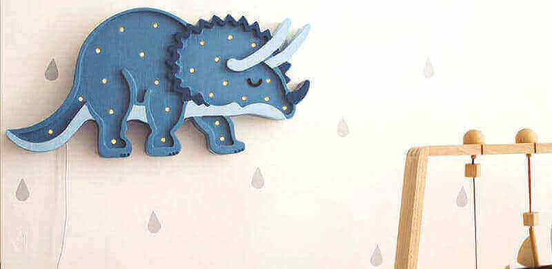 Dino-Lampen - Dinosaurier fürs Kinderzimmer, blaue Triceratops-Lampe an Wand mit Tropfenmuster.