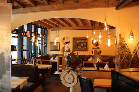 Gemütliches Restaurant-Interieur mit warmem Licht und stilvollen Lampen, ideal für eine einladende Atmosphäre.