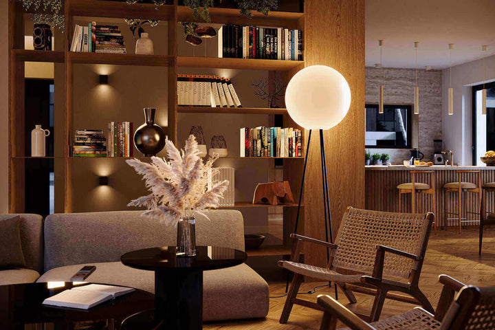 Moderne Wohnzimmer mit Tripod-Stehlampen und stilvollen Möbeln, die Atmosphäre und Design vereinen.