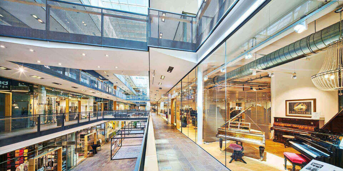 Die perfekten Lampen für Deine hohe Decke in einem modernen Einkaufszentrum mit Glasfassade.