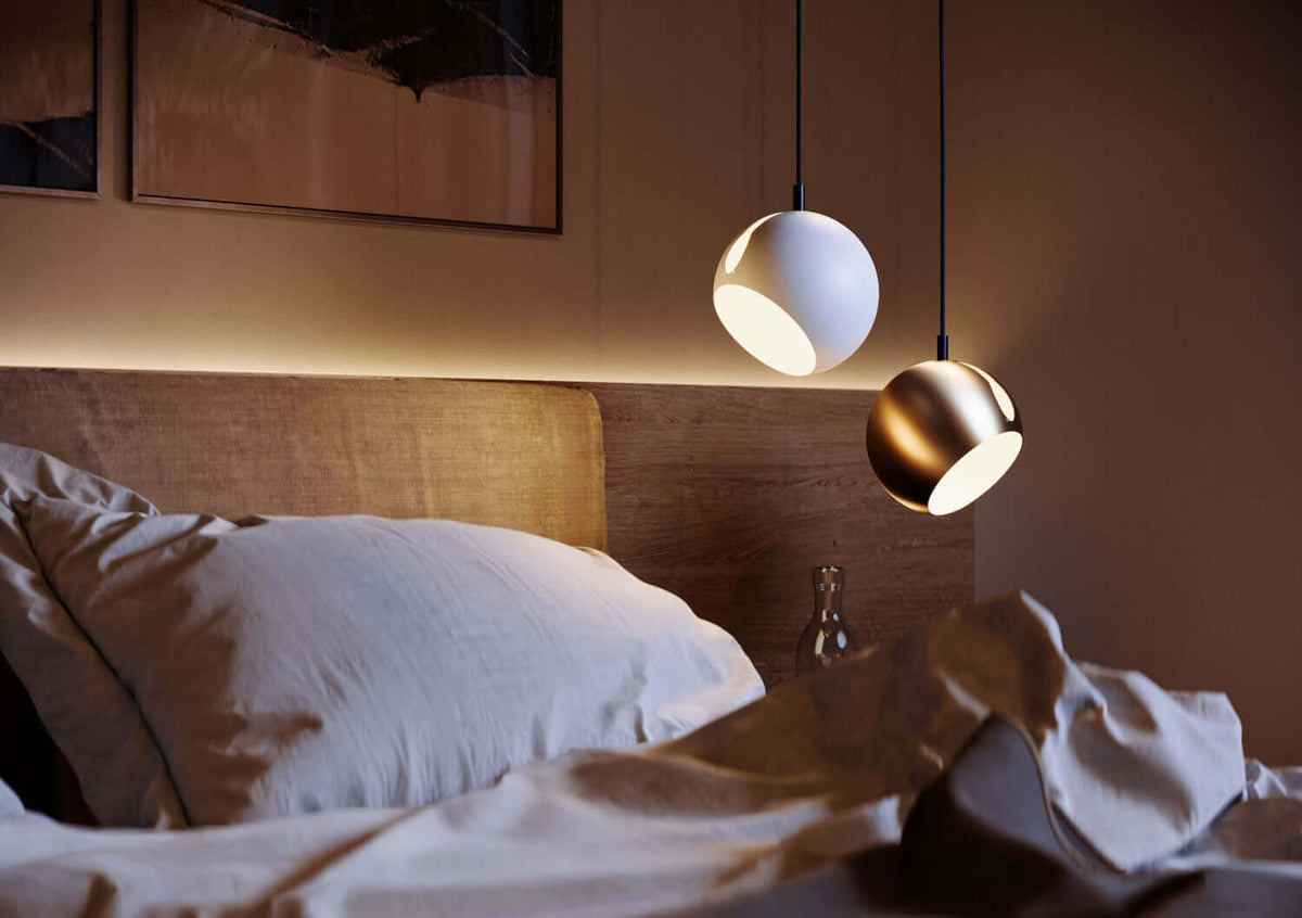 Moderne Pendelleuchten über einem Bett sorgen für stilvolle Beleuchtung im Schlafzimmer.