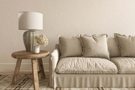 Gemütliches Wohnzimmer mit beigem Sofa, rustikalem Tisch und moderner Lampe für skandinavischen Einrichtungsstil.