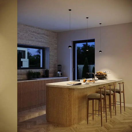 Pendelleuchte Kücheninsel in modernem Raum mit Holzdetails und eleganter Beleuchtung.