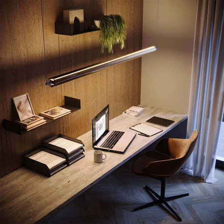 Moderne Pendelleuchte über einem stilvollen Büroarbeitsplatz mit Laptop und Büromaterialien.