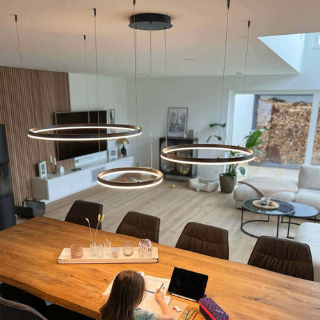 Moderne LED-Pendelleuchte über einem Esstisch in einem stilvollen Wohnzimmer.