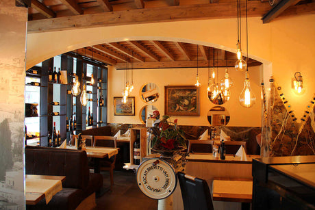 Gemütliches Restaurant-Interieur mit warmem Licht und stilvollen Lampen, ideal für eine einladende Atmosphäre.