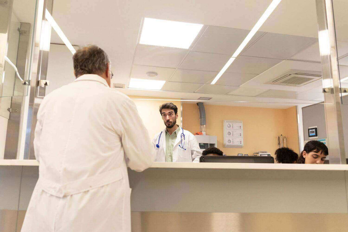 Moderne Praxis Beleuchtung professionell geplant! Ärzte im Behandlungsraum während einer Konsultation.