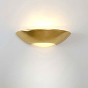 Matteo ceramic wall light in gold leaf, elegant gold wall lamp with soft lighting.