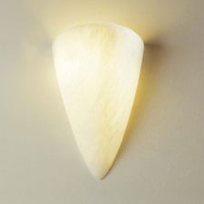 Aplique Kyra Alabastro blanco natural montado en una pared, ofrece una luz suave y difusa.