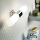 Tangens Wandleuchte Chrom an Badezimmerwand in schlichtem Design mit weißem Licht.
