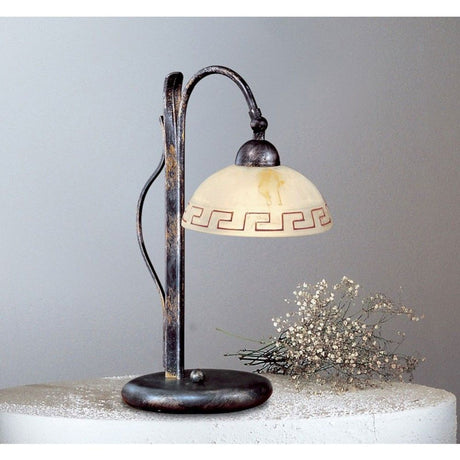 Greca Tischleuchte Schwarz-Gold-Silber 40cm auf einem Tisch mit dekorativem Hintergrund.