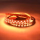 36 W/m RGBW Warmweiß 24V 5m LED-Strip IP20 auf Rolle, leuchtend in warmem Orange.