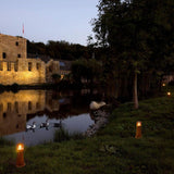 Rustikale Außenleuchten der RUSTY Serie am Ufer eines ruhigen Gewässers bei Nacht, umgeben von Natur.